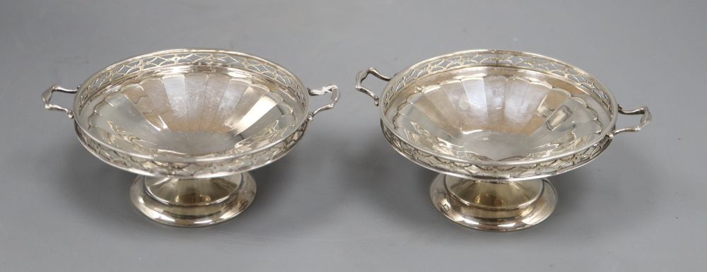 A pair of silver two handled bon bon dishes, with pierced gallery on circular bases, Birmingham 1925, 5.1oz. gross, width 11cm